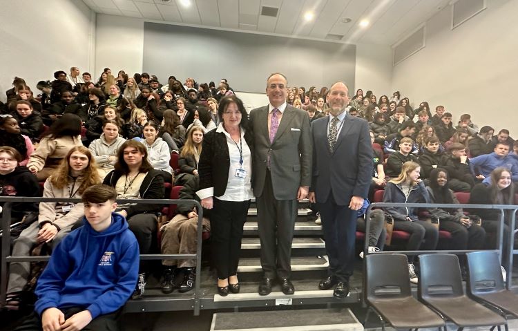 Michael Ellis MP poses with college Principal Pat Brennan-Barrett, Curriculum Manager Michael Colbourne, and a lecture theatre full of students.